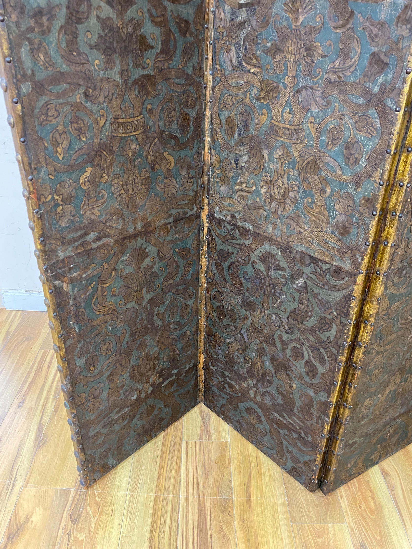 A 19th century French studded leather four fold screen, each panel width 49cm, height 182cm